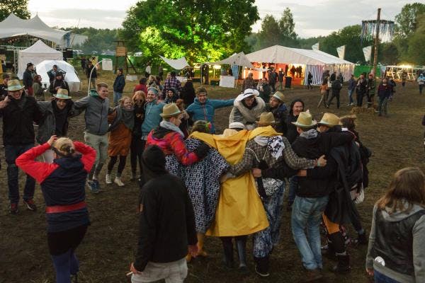 Menschen auf der Festivalfläche, die im Regen tanzen