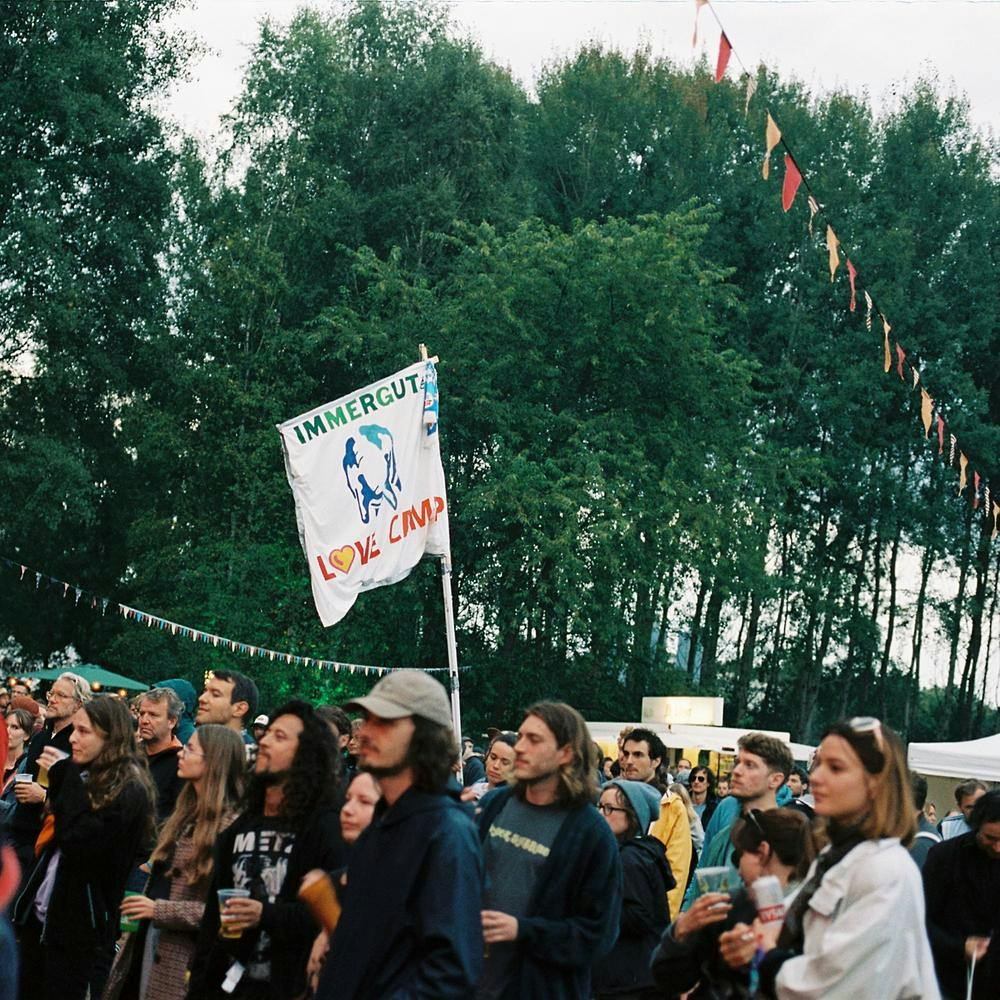 Menschen im Publikum beim Immergut Festival 2021 mit Fahne "Immergut Lovecamp"